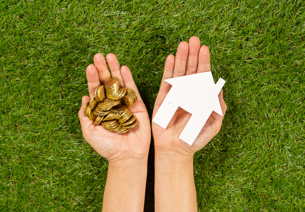 Hands holding house and coins